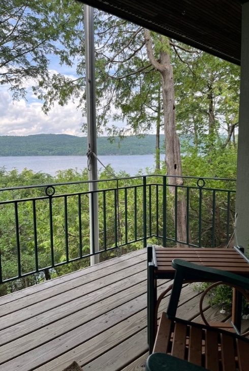 View from a residential deck overlooking a bay through the canopy of mature trees